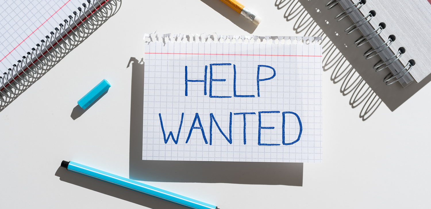A piece of notebook paper with "Help Wanted" written on it.